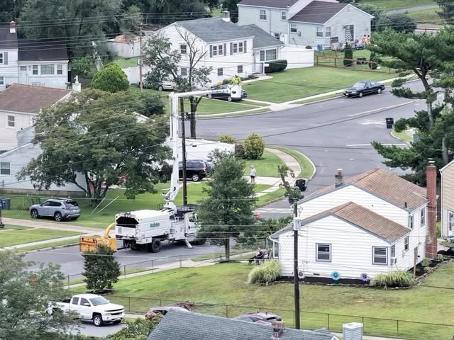 Aerial view of a utility bucket truck servicing power lines in a neighborhood